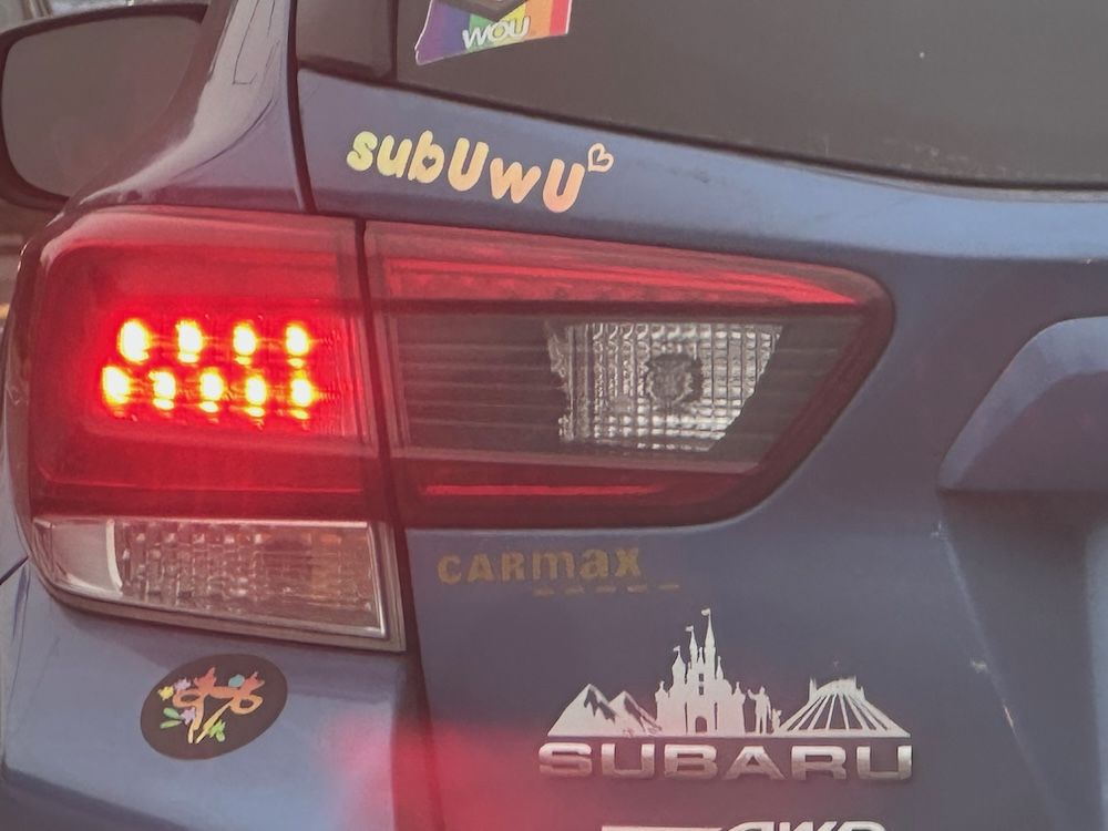 Bumperstickers on the back of a Subaru, inccluding one reading "SubUWU", as seen in Salem, OR