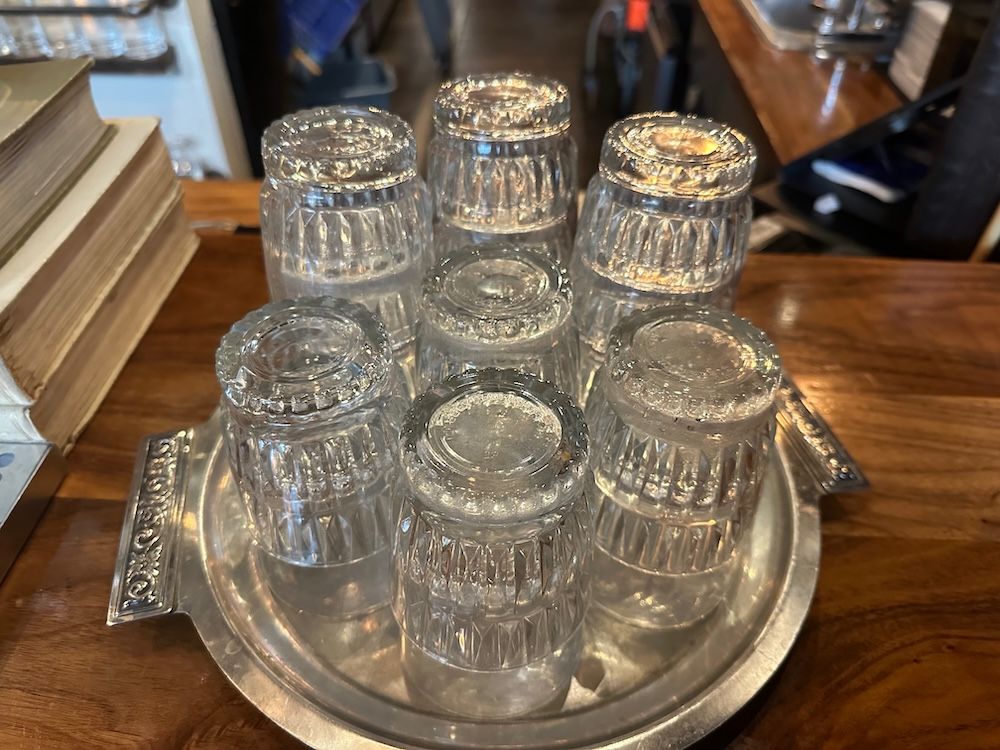 an arrangement of drinking glasses on a silver platter